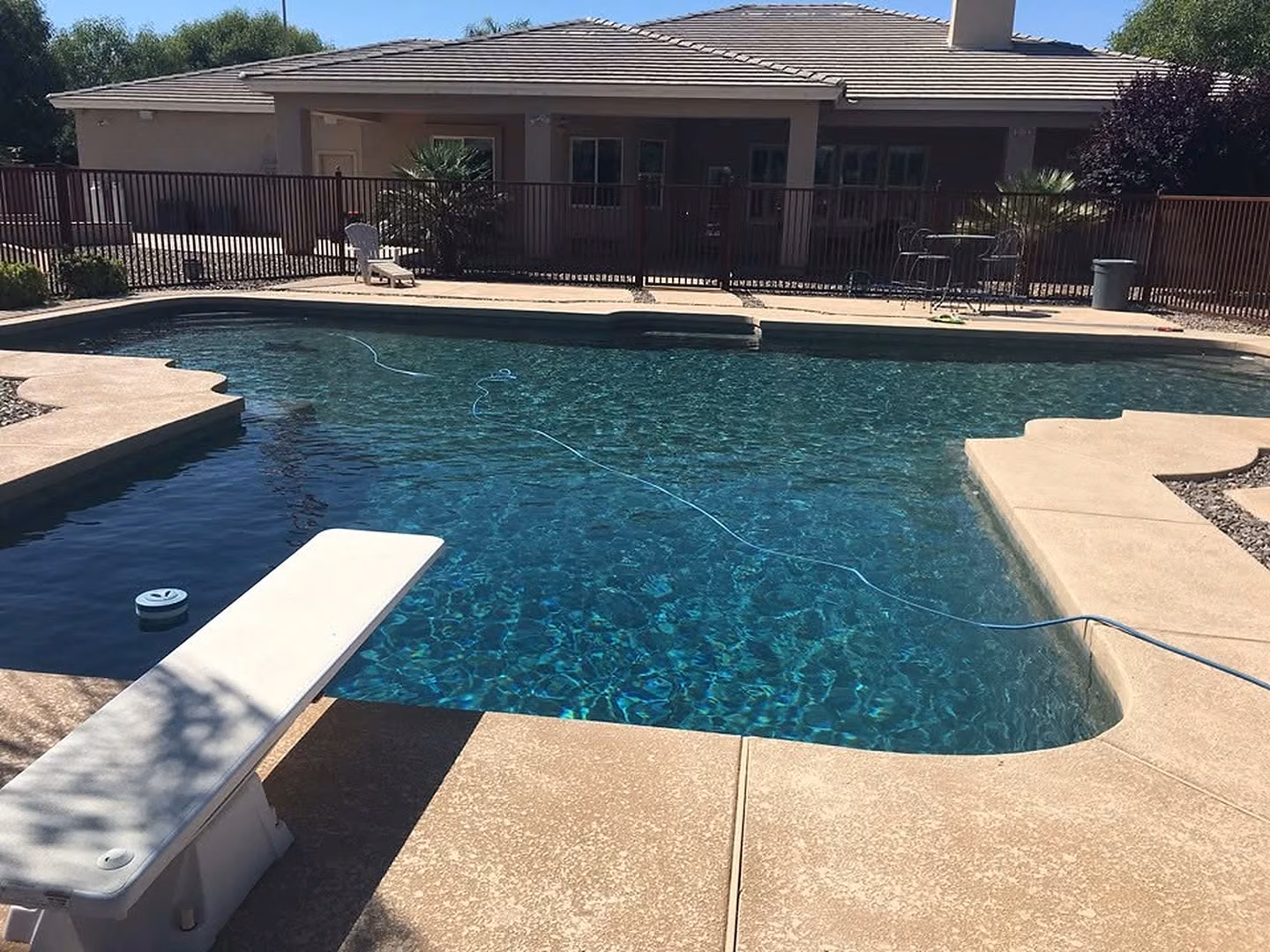 Residential swimming pool with blue water and a stone deck